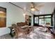 Relaxing screened patio furnished with wicker furniture, ceiling fan, and tile flooring at 17631 Grove View Dr, Lutz, FL 33549