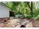 Stone patio with a wicker chair and beautiful views of the surrounding trees and landscaping at 17631 Grove View Dr, Lutz, FL 33549