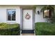Charming home entrance with a decorative floral wreath, manicured bushes, and natural light at 1851 Bough Ave # A, Clearwater, FL 33760