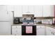 Bright kitchen features white appliances and white cabinets at 1851 Bough Ave # A, Clearwater, FL 33760