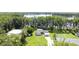An aerial view of a home with a lush lawn surrounded by trees and views of the adjacent lake at 19209 Crooked Ln, Lutz, FL 33548