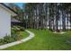 Lush backyard with walkway to firepit, leading to lake and surrounded by tall trees at 19209 Crooked Ln, Lutz, FL 33548