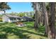 Firepit and Adirondack chairs nestled under mature trees, perfect for entertaining at 19209 Crooked Ln, Lutz, FL 33548