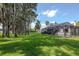 Expansive backyard with screened-in lanai and view of the lush landscaping and beautiful trees at 19209 Crooked Ln, Lutz, FL 33548