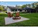 Backyard firepit and Adirondack chairs nestled under mature trees, perfect for entertaining at 19209 Crooked Ln, Lutz, FL 33548