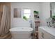 Bright bathroom features a freestanding tub, decoratives, and a white vanity at 19209 Crooked Ln, Lutz, FL 33548
