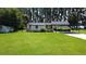 Single-story home featuring a lush green lawn and an attached carport and additional storage shed at 19209 Crooked Ln, Lutz, FL 33548