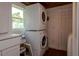 This laundry area features stacked washer/dryer units and storage next to a window at 19209 Crooked Ln, Lutz, FL 33548