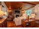 Cozy living room with hardwood floors, a brick fireplace, and comfortable seating at 19209 Crooked Ln, Lutz, FL 33548