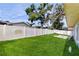 This backyard features a white vinyl fence, vibrant green lawn, mature trees, and a cozy fire pit, perfect for outdoor gatherings at 206 Hillcrest Dr, Safety Harbor, FL 34695