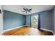 Bedroom with blue walls, hardwood floors, ceiling fan, and a large window at 206 Hillcrest Dr, Safety Harbor, FL 34695