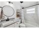 Bright bathroom with a large vanity, round mirror, and a shower-tub combo with modern fixtures at 2108 Delightful Dr, Ruskin, FL 33570
