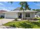 Home with two-car garage, landscaped front yard, and a wreath on the blue front door at 2108 Delightful Dr, Ruskin, FL 33570