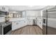 Modern kitchen showcasing white cabinets, stainless steel appliances, and wood-look flooring at 2108 Delightful Dr, Ruskin, FL 33570