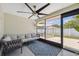 Relaxing screened porch featuring tile floors, cozy seating, a ceiling fan, and a backyard view at 2108 Delightful Dr, Ruskin, FL 33570