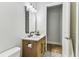 Bright bathroom features a wood vanity, stylish mirror, and modern fixtures, alongside a view of the closet at 238 7Th S Ave, Safety Harbor, FL 34695