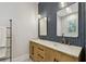 This bathroom boasts double sinks, wooden vanity, herringbone backsplash, and modern light fixtures at 238 7Th S Ave, Safety Harbor, FL 34695