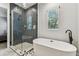 This bathroom features herringbone tile in the glass shower and soaking tub under a window at 238 7Th S Ave, Safety Harbor, FL 34695