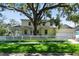 Charming two-story home featuring a white picket fence, lush lawn, and mature tree providing ample shade at 238 7Th S Ave, Safety Harbor, FL 34695