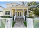 Charming two-story home features a welcoming front porch with white picket fence and lush landscaping at 238 7Th S Ave, Safety Harbor, FL 34695