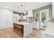 Bright kitchen features white cabinets, subway tile, marble countertops, large island with seating and stainless steel appliances at 238 7Th S Ave, Safety Harbor, FL 34695