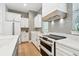 A modern kitchen showcasing white cabinets, stainless steel appliances, and a sleek cooktop at 238 7Th S Ave, Safety Harbor, FL 34695