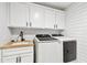 Well-lit laundry room boasts updated appliances, a sink with modern faucet, and ample storage at 238 7Th S Ave, Safety Harbor, FL 34695