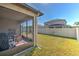 Enclosed patio with outdoor furniture and a spacious, well-maintained backyard at 25200 Lambrusco Loop, Lutz, FL 33559