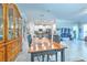 Open-concept dining area showcasing an oversized wood table and chairs, seamlessly connecting to a modern kitchen and living space at 25200 Lambrusco Loop, Lutz, FL 33559