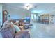 Open-concept living space with leather furniture, tile flooring, and a seamless flow between dining and seating areas at 25200 Lambrusco Loop, Lutz, FL 33559