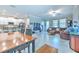 Bright living room featuring an open layout, tile floors, and seamless flow to a modern kitchen and dining space at 25200 Lambrusco Loop, Lutz, FL 33559