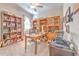 Bright office features custom wood shelving, a ceiling fan, and a comfortable work space at 25200 Lambrusco Loop, Lutz, FL 33559