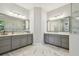 Elegant bathroom featuring dual vanities, stylish gray cabinetry, and beautiful marble flooring at 2648 Lake Manor Dr, Land O Lakes, FL 34639