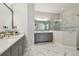 Bright bathroom featuring dual vanities, marble countertops, and a spacious walk-in shower at 2648 Lake Manor Dr, Land O Lakes, FL 34639