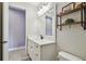 Well-lit bathroom with a white vanity and modern fixtures, and a decorative shelf at 2648 Lake Manor Dr, Land O Lakes, FL 34639