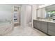 Spa-like bathroom featuring a soaking tub, separate vanity, and serene neutral color palette at 2648 Lake Manor Dr, Land O Lakes, FL 34639