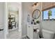 Charming bathroom features a round mirror, and natural light from the window with wood blinds at 2648 Lake Manor Dr, Land O Lakes, FL 34639