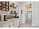 Coffee bar area featuring white cabinets, shelving, coffee machine, and assorted flavor syrups at 2648 Lake Manor Dr, Land O Lakes, FL 34639