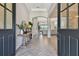 Elegant foyer featuring wood-look tile flooring, a console table and an open living area at 2648 Lake Manor Dr, Land O Lakes, FL 34639