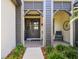 Stylish front porch with double doors, a seating area, and lush plants at 2648 Lake Manor Dr, Land O Lakes, FL 34639
