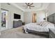 Neutral-toned main bedroom with a TV and access to the en-suite bath at 2648 Lake Manor Dr, Land O Lakes, FL 34639