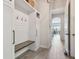 Bright mudroom features built-in storage, wood bench, coat hooks, and wood-look tile flooring at 2648 Lake Manor Dr, Land O Lakes, FL 34639