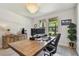Well-lit home office featuring modern design, a large desk, and views of the lush exterior at 2648 Lake Manor Dr, Land O Lakes, FL 34639