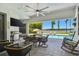 Covered patio boasts an outdoor kitchen, dining, seating, and views of the pool and lake at 2648 Lake Manor Dr, Land O Lakes, FL 34639