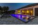 Inviting outdoor pool with elegant water feature, sun loungers, and access to covered outdoor dining area at 2648 Lake Manor Dr, Land O Lakes, FL 34639