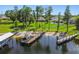 Stunning lakefront property featuring a private dock, boat lift, and beautiful lawn leading to the water's edge at 2648 Lake Manor Dr, Land O Lakes, FL 34639