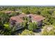 A high-angle view of the condo building showcasing the central courtyard, red-tile roofs, and lush surrounding greenery at 2650 Countryside Blvd # C204, Clearwater, FL 33761