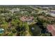 An aerial view of a well-maintained condo surrounded by trees, a landscaped pond with a fountain, and nearby conveniences at 2650 Countryside Blvd # C204, Clearwater, FL 33761
