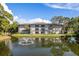 Condo building overlooking a serene pond with a fountain in a lush, landscaped community at 2650 Countryside Blvd # C204, Clearwater, FL 33761