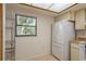 A view of the kitchen showing stainless steel shelving, a window and a refrigerator at 2650 Countryside Blvd # C204, Clearwater, FL 33761